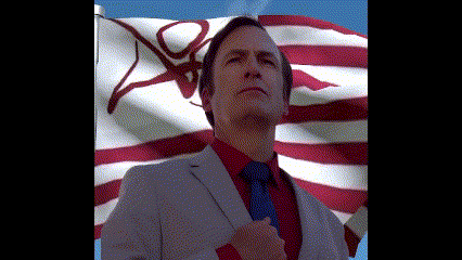 a man in a suit and tie stands in front of a flag