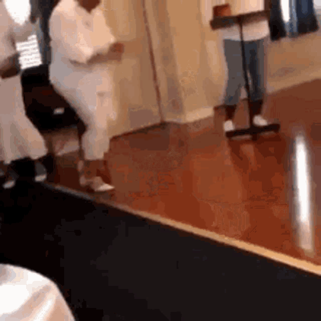 a group of people are dancing in a room .