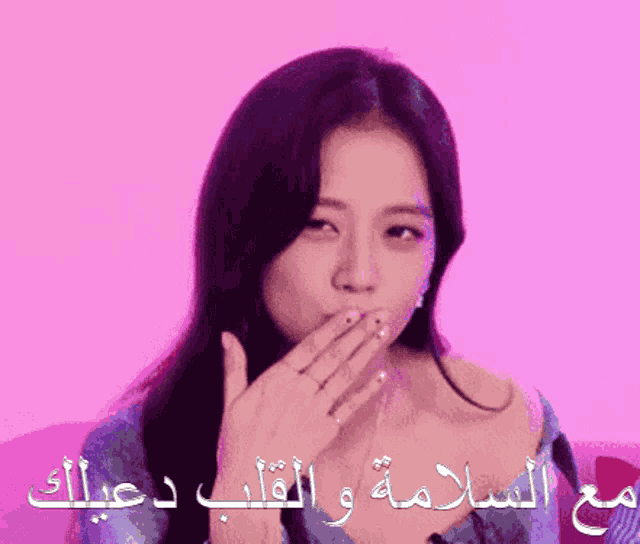 a woman blowing a kiss with a pink background and arabic writing