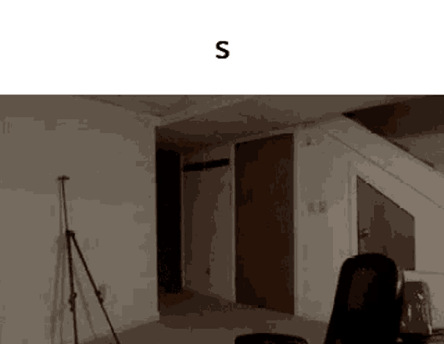 a room with a chair and a tripod and the letter s on the bottom