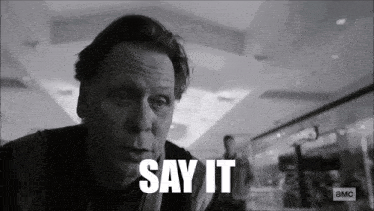 a black and white photo of a man with the words say it in white letters