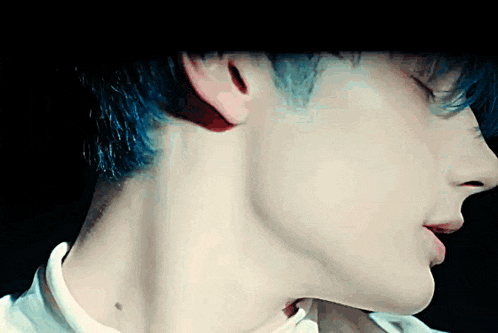 a close up of a man 's neck and ear with blue hair