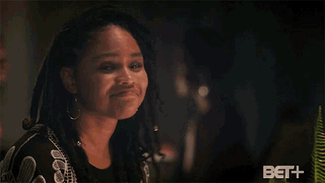 a woman with dreadlocks is smiling next to a sign that says crazy right
