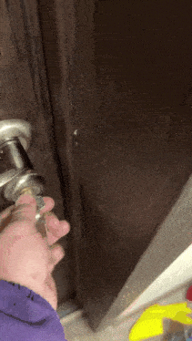 a close up of a person 's hand holding a door handle
