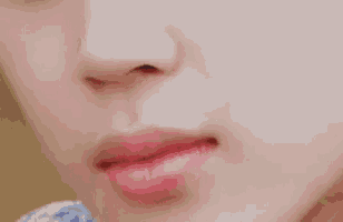 a close up of a woman 's face with her mouth open