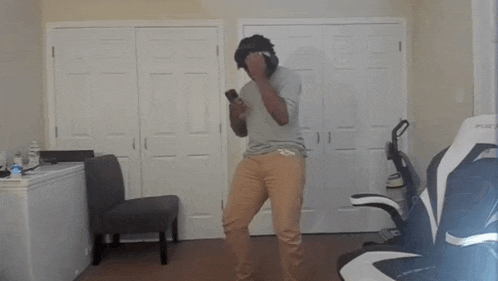 a man wearing a virtual reality headset dancing in a room