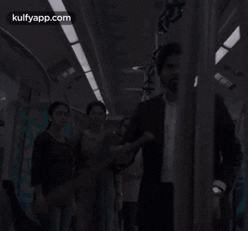 a man in a suit is holding a stick while riding a train .