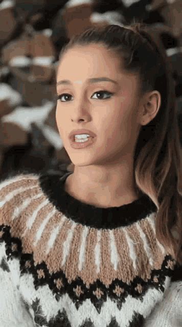 a close up of a woman wearing a sweater with a pattern on it