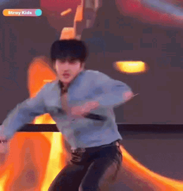a young man is dancing in front of a fire .