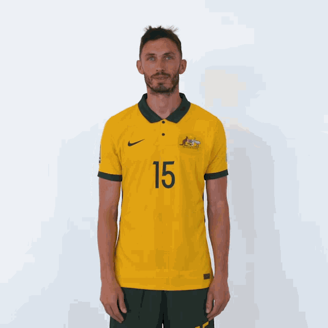 a man is wearing a yellow shirt with the number 15 on it