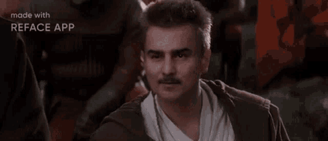 a man with a mustache is sitting at a table with a group of people .