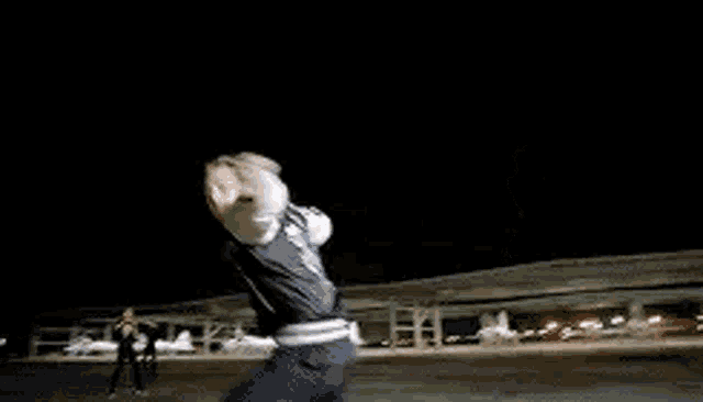 a person is dancing on a stage in a dark room .