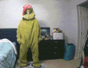 a person in a green monster costume is standing in a room