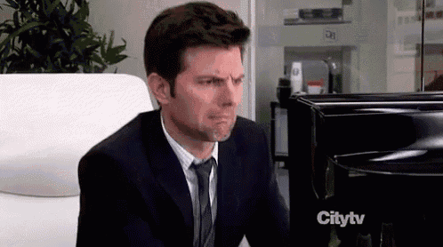a man in a suit and tie is crying in front of a piano .