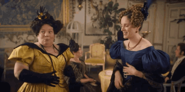 a woman in a yellow dress and a woman in a blue dress are standing next to each other
