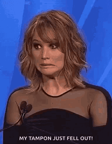 a woman is making a funny face while holding a microphone .