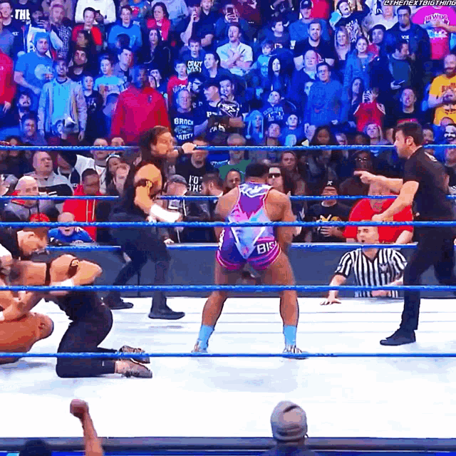 a man in a wrestling ring wearing a shirt that says " big "