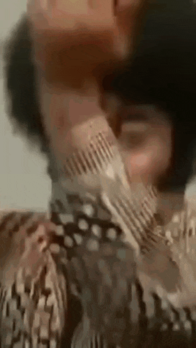 a man with a beard is covering his face with his hands .