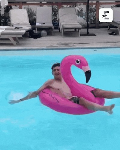 a man is floating in a pink flamingo float in a pool