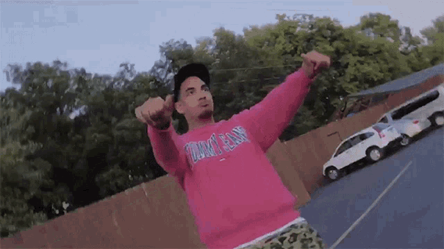 a man wearing a pink tommy jeans sweatshirt