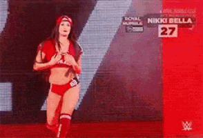 a woman in a red wrestling outfit is running on a red carpet .