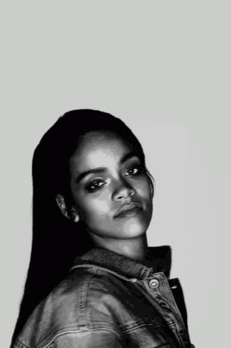 a black and white photo of a woman wearing a denim jacket and earrings