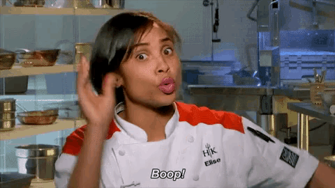 a woman in a chef 's uniform is making a funny face and saying boop