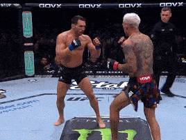 two men are fighting in a ring with govx written on the fence