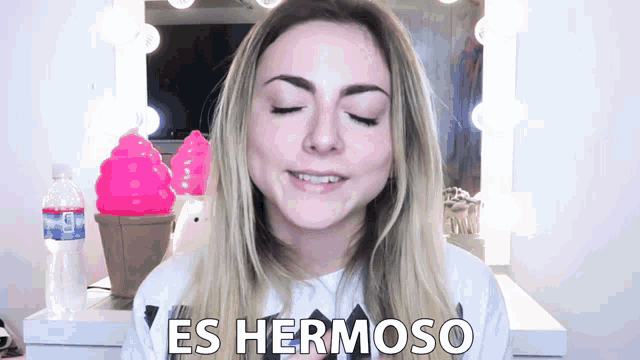 a woman in front of a mirror with the words es hermoso on her shirt