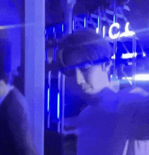 a man is standing in a dark room with blue lights and a sign that says ice