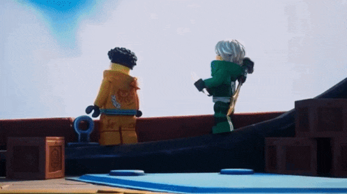 a couple of lego figures standing next to each other on a boat .