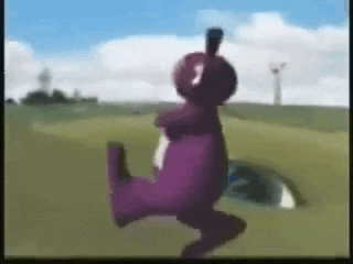 a purple teddy bear is dancing in a field with a windmill in the background .