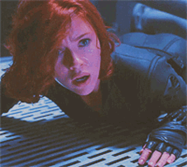 a woman with red hair is laying on her stomach