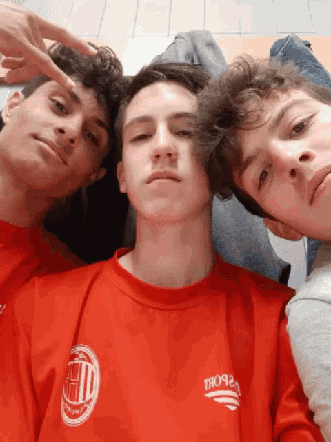 three young men are posing for a picture with one wearing a red shirt that says " tropicana "