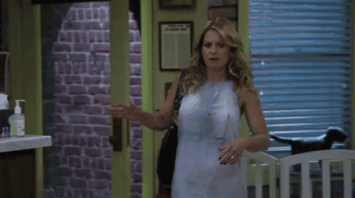 a woman in a white dress stands in front of a door