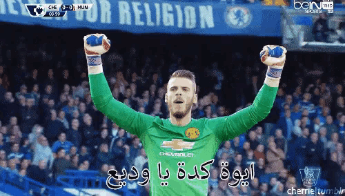 a soccer player with his arms in the air in front of a banner that says religion