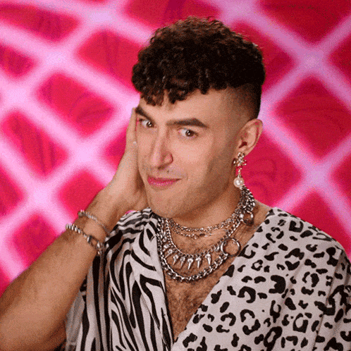 a man wearing a zebra print shirt and earrings is making a funny face