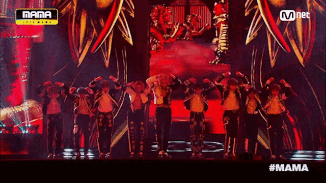 a group of people are dancing on a stage with a mnet logo in the background