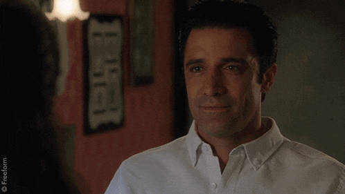 a man in a white shirt looks at a woman