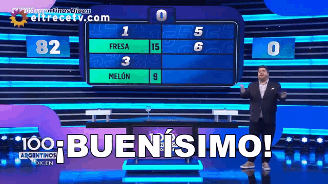 a man in a suit stands in front of a scoreboard that says 100 buenisimo