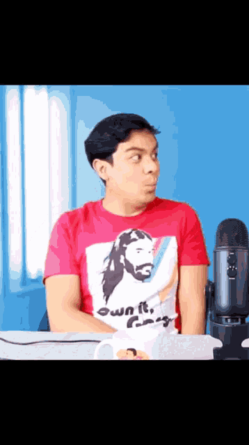 a man wearing a red t-shirt with jesus on it