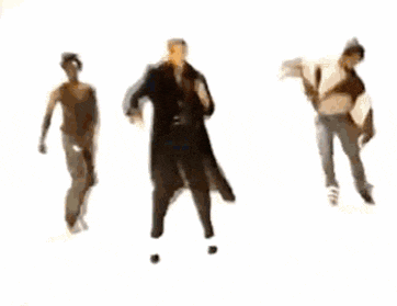 a group of people are dancing in a room with a man standing in the middle .