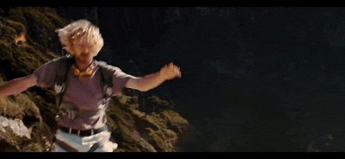 a man with a backpack is walking down a hill at night