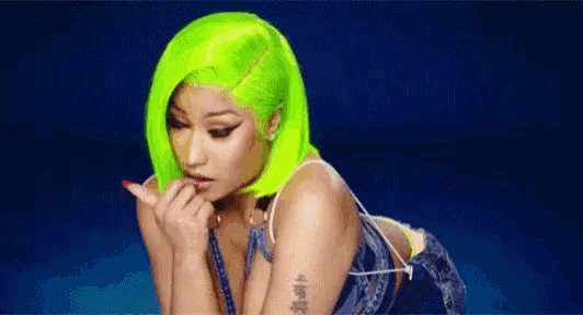 a woman with neon green hair is wearing a denim dress and a neon green wig .