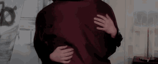 a man and a woman are hugging each other in a room in front of a lamp .