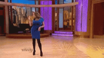 a woman in a blue dress is dancing on a stage with the word wendy in the background