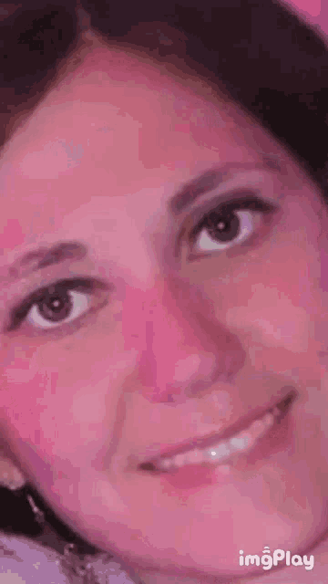 a close up of a person 's eye on a pink background with imgplay at the bottom