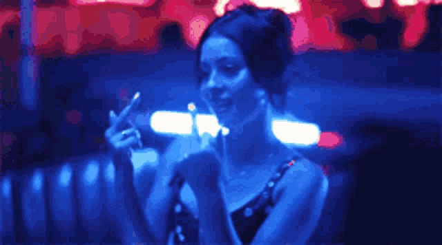 a woman in a blue dress is giving the middle finger in a dark room