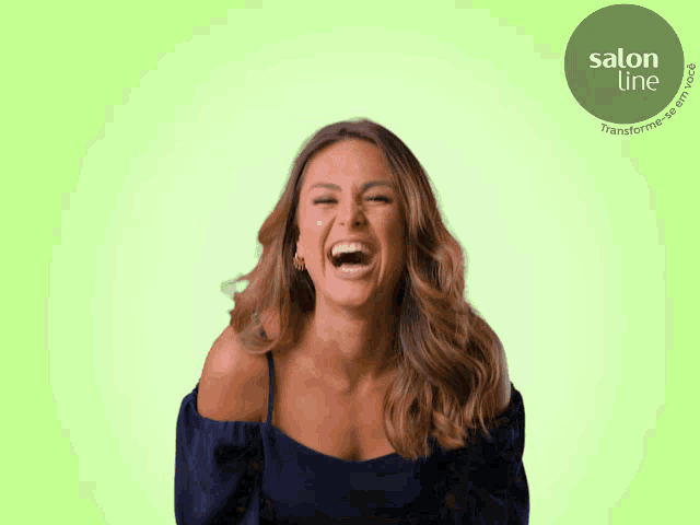 a woman is laughing in front of a green background with salon line written on it