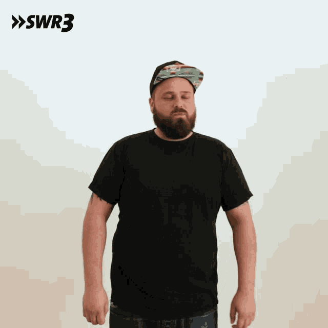 a man wearing a hat and a black shirt is standing with his eyes closed in front of a swr3 sign